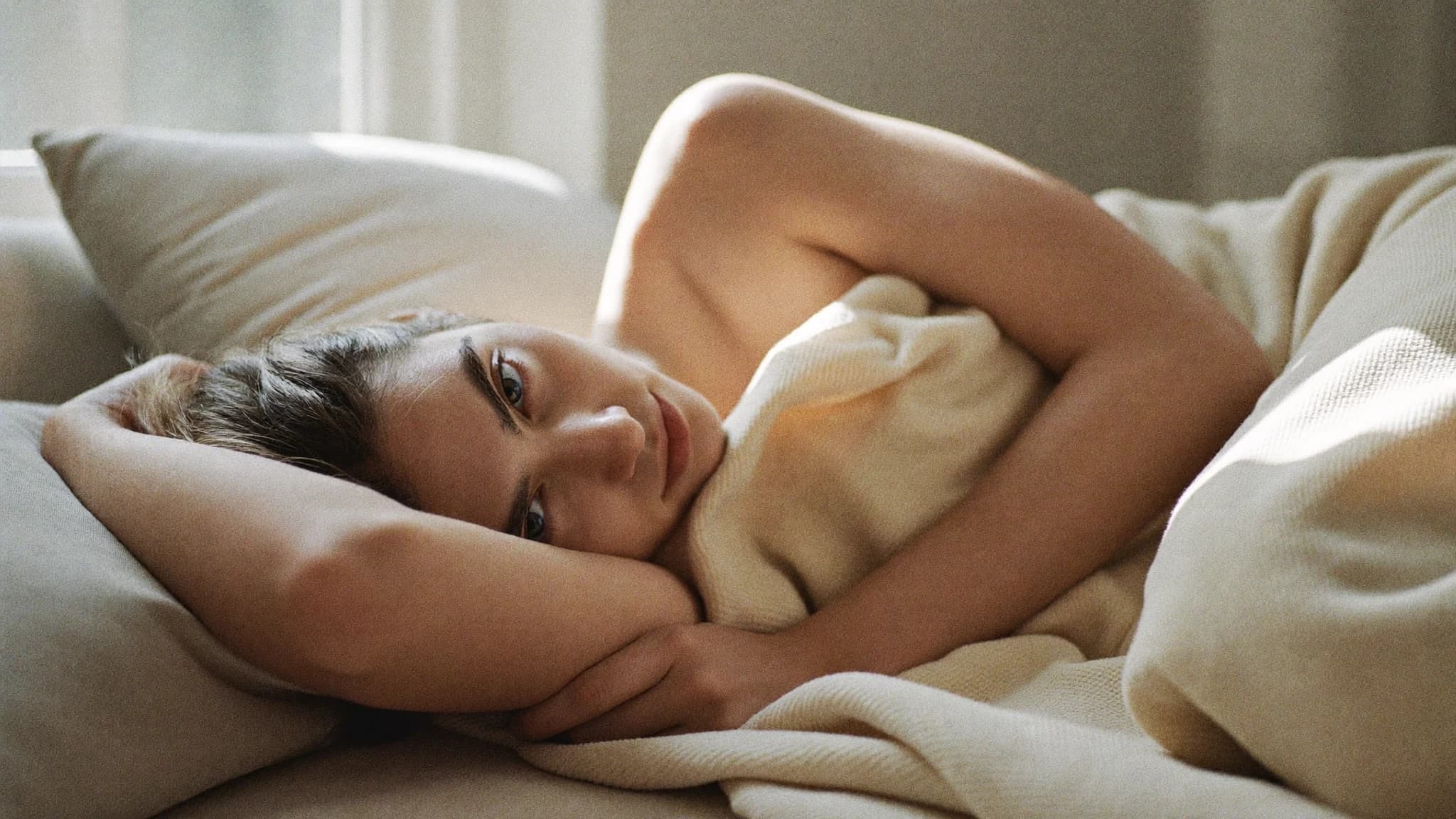 Person ruht tagsüber erschöpft unter einer Decke auf dem Sofa — symbolisch für Selbstfürsorge bei Fibromyalgie