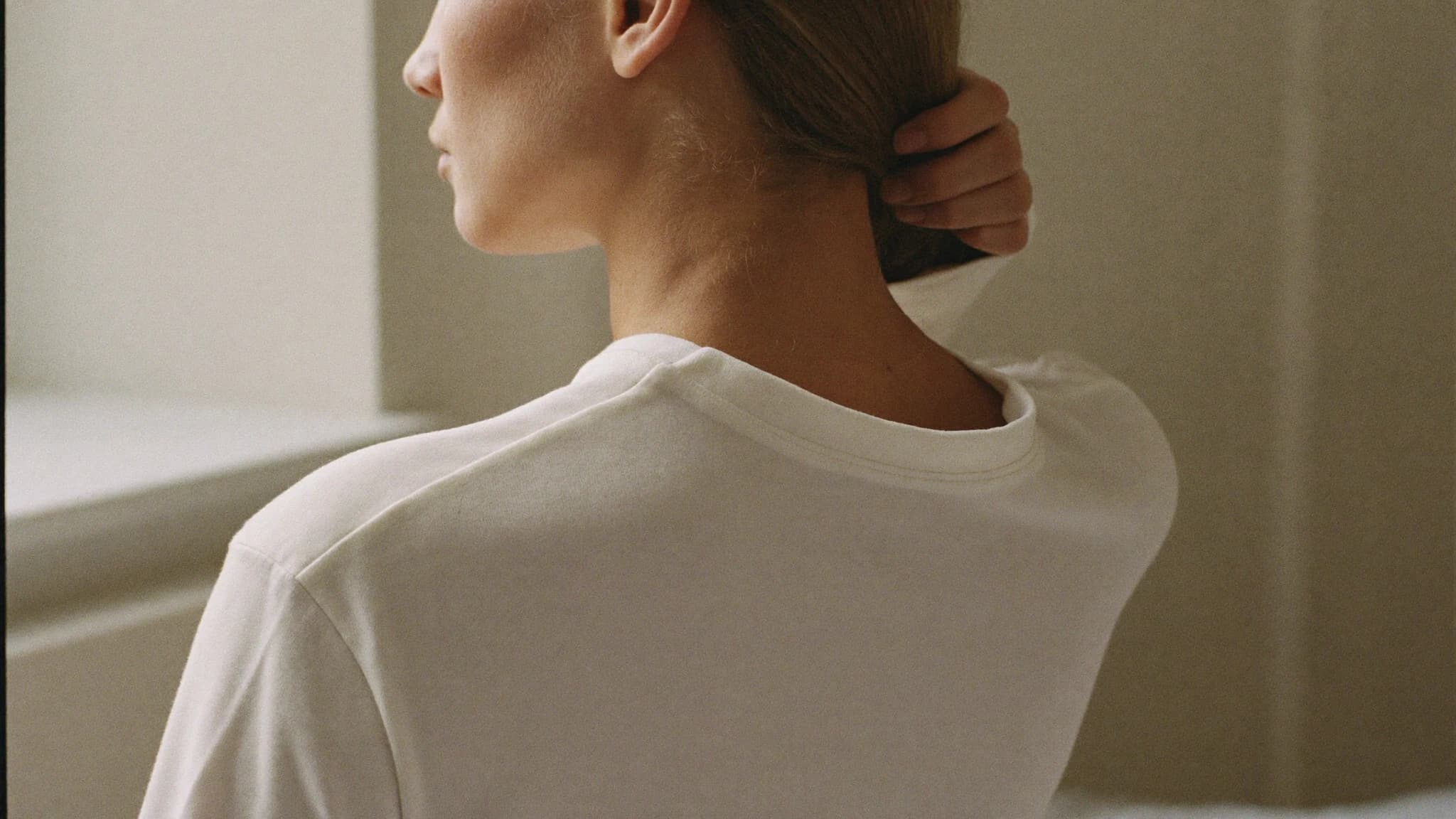 Ruhiges Porträt einer Person, die sich die Haare hinters Ohr streicht — symbolisch für Entspannung bei Tinnitus